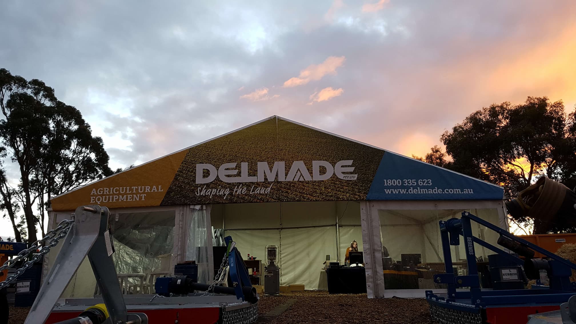 Delmade at Agfest 2019.  Tent, Agricultural Equipment and Sunset in the Background